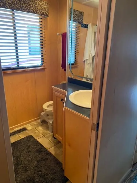 Slide: The Image of 2006 Sumerset Houseboat bathroom with sink, toilet, and window blinds. - 16