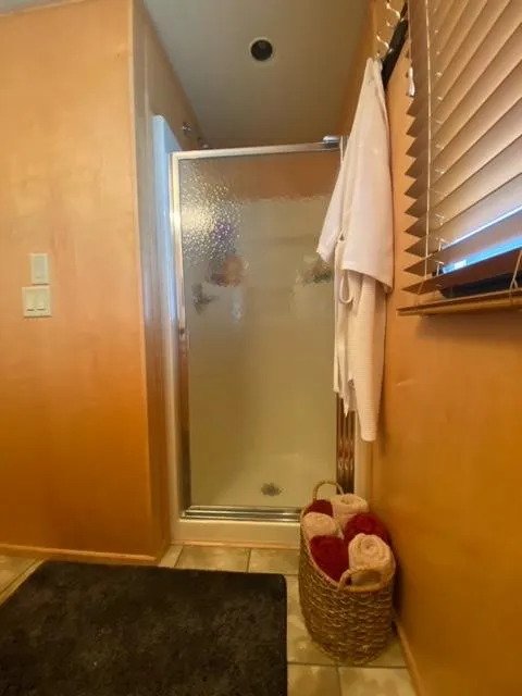 Slide: The Image of Bathroom in a 2006 Sumerset Houseboat with shower, towels, and window blinds. - 17