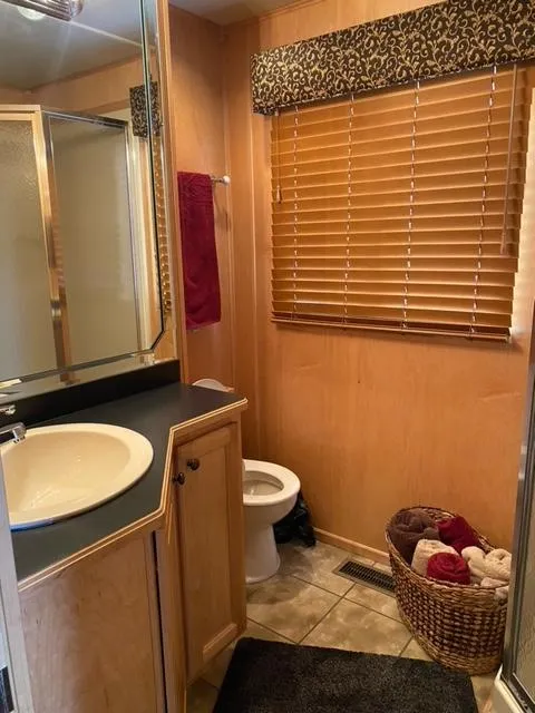 Slide: The Image of 2006 Sumerset Houseboat bathroom with sink, toilet, shower, and wicker basket. - 18