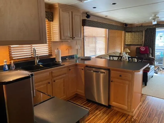 Slide: The Image of Modern kitchen interior on a 2006 Sumerset Houseboat with wooden cabinets and stainless steel appliances. - 7