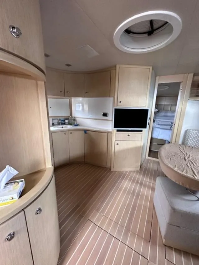 Slide: The Image of Interior of 2006 Baia 63 Azzurra yacht with modern kitchen and cozy seating area. - 14