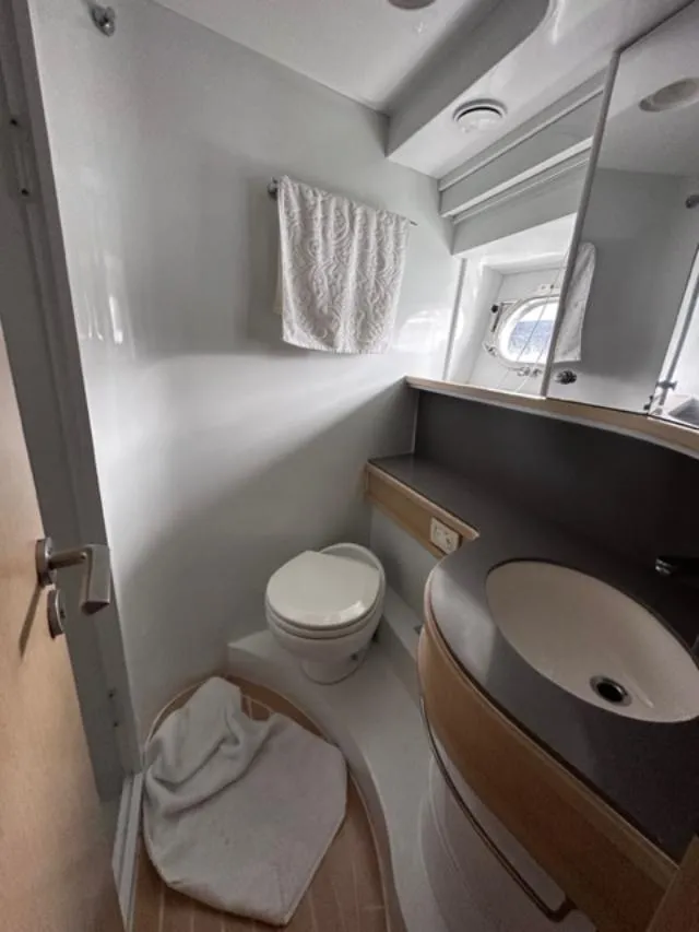 Slide: The Image of 2006 Baia 63 Azzurra yacht bathroom with modern fixtures and a porthole window. - 16
