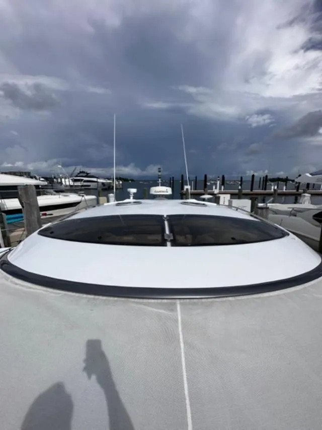 Slide: The Image of 2006 Baia 63 Azzurra yacht docked at a marina under cloudy skies. - 22