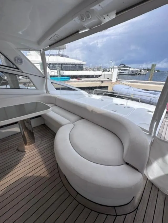 Slide: The Image of Interior of 2006 Baia 63 Azzurra yacht with curved seating and dock view. - 3