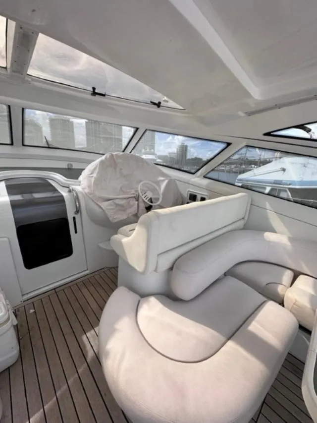 Slide: The Image of Interior of 2006 Baia 63 Azzurra yacht with white leather seating and wooden flooring. - 4