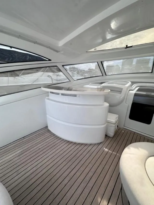 Slide: The Image of Interior of 2006 Baia 63 Azzurra yacht with modern white furnishings and wooden flooring. - 5