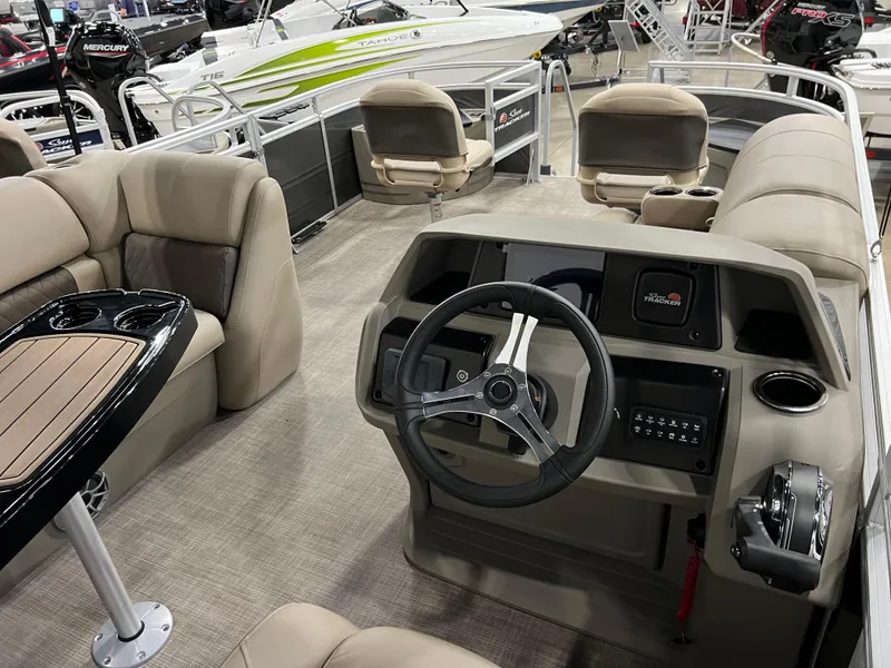 Slide: The Image of 2024 Sun Tracker Fishin' Barge 20 DLX interior with steering console and seating. - 2