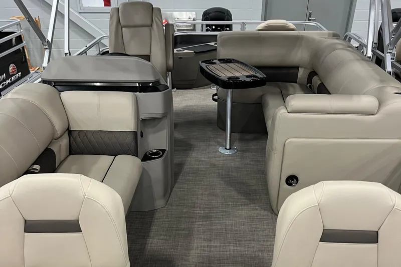 Slide: The Image of 2024 Sun Tracker Fishin' Barge 20 DLX interior with beige seating and table. - 3