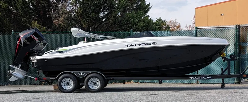 Slide: The Image of 2024 Tahoe T21 boat on trailer, black and white design, parked outdoors. - 15