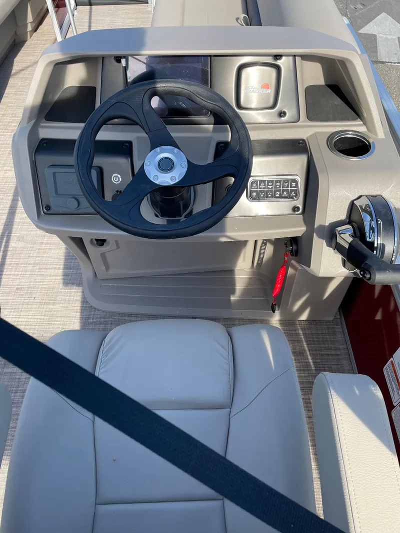 Slide: The Image of 2024 Sun Tracker Party Barge 18 DLX helm with steering wheel and control panel. - 2