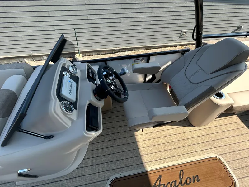 Slide: The Image of 2024 Avalon LSZ 2385 EL boat cockpit with steering wheel and captain's chair. - 17