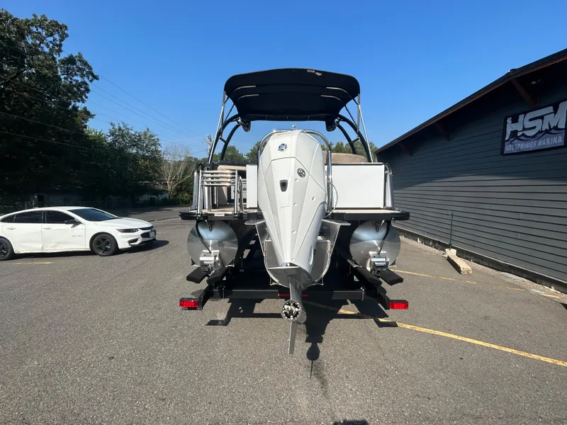 Slide: The Image of 2024 Avalon LSZ 2385 EL pontoon boat rear view in parking lot. - 2