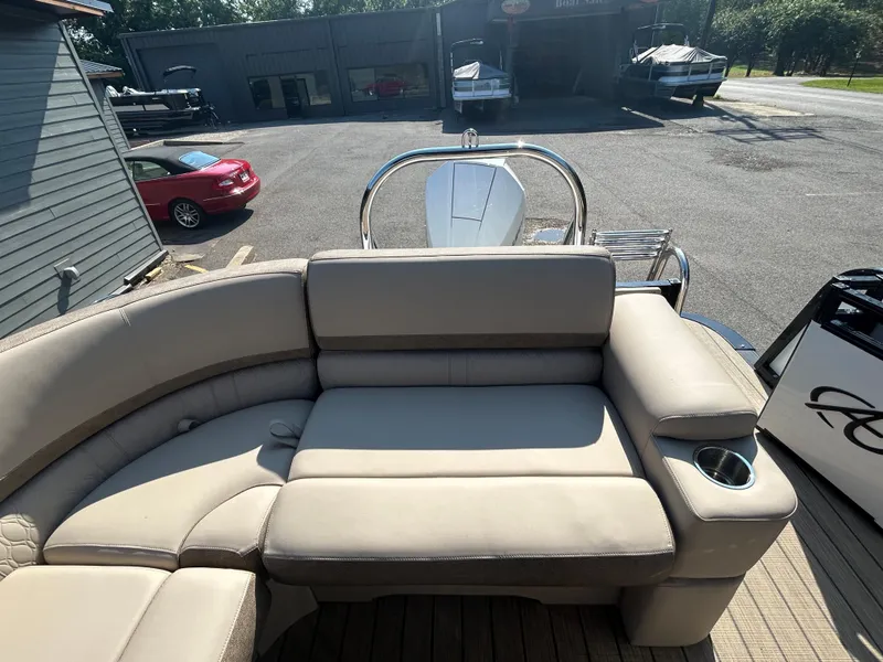 Slide: The Image of 2024 Avalon LSZ 2385 EL pontoon boat with beige seating and cup holder. - 24