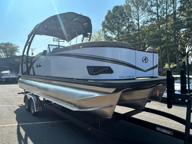 Slide: The Image of 2024 Avalon LSZ 2385 EL pontoon boat on a trailer in a parking lot. - 6