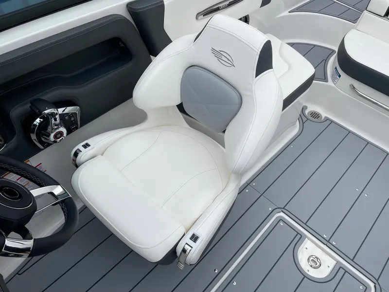 Slide: The Image of 2024 Chaparral 247 SSX boat interior with white captain's chair and gray flooring. - 11