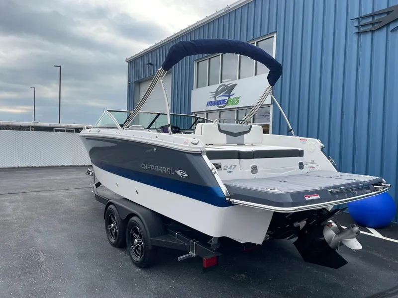Slide: The Image of 2024 Chaparral 247 SSX boat on a trailer outside a blue building. - 2