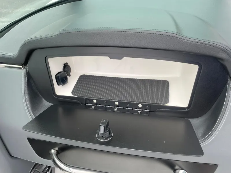 Slide: The Image of 2024 Chaparral 247 SSX boat dashboard storage compartment with USB ports. - 46