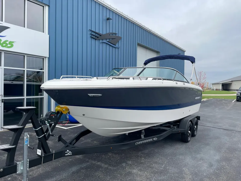 Slide: The Image of 2024 Chaparral 247 SSX boat on a trailer outside a blue building. - 8