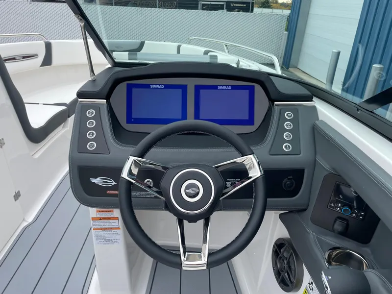 Slide: The Image of 2024 Chaparral 247 SSX boat dashboard with dual Simrad displays and modern steering wheel. - 9
