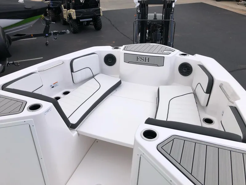 Slide: The Image of 2023 Yamaha Boats 222 FSH Sport E interior seating area with white and black cushions. - 10