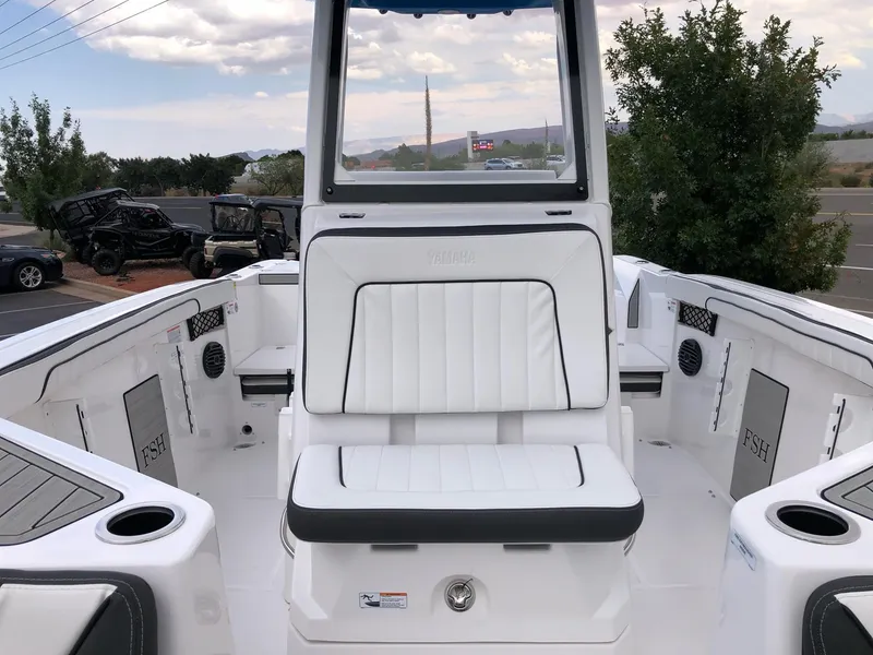 Slide: The Image of 2023 Yamaha Boats 222 FSH Sport E interior with white seating and storage compartments. - 11