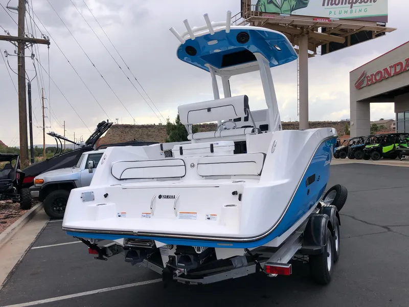 Slide: The Image of 2023 Yamaha Boats 222 FSH Sport E, rear view in parking lot. - 6