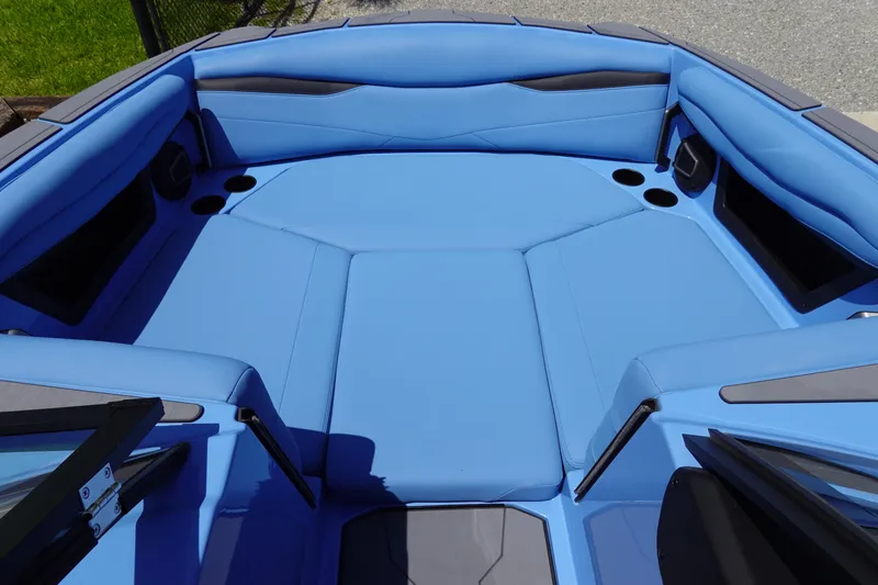 Slide: The Image of 2024 Axis A225 boat with blue interior seating and cup holders. - 22