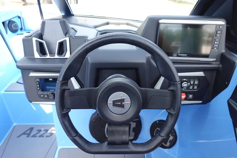 Slide: The Image of 2024 Axis A225 boat dashboard with steering wheel and Garmin display. - 24