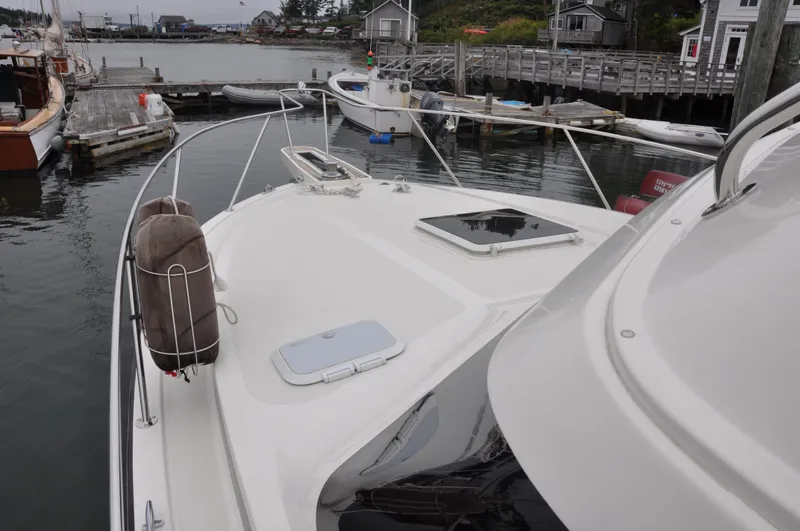 Slide: The Image of 1987 Bertram 37 Convertible yacht docked at a marina, showcasing its bow and deck. - 17