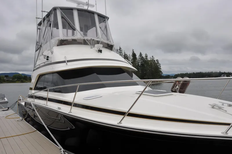 Slide: The Image of 1987 Bertram 37 Convertible yacht docked on a cloudy day. - 2