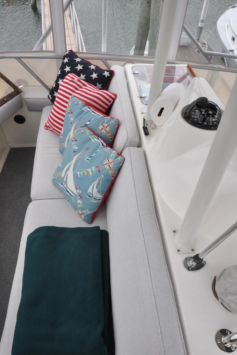 Slide: The Image of 1987 Bertram 37 Convertible boat interior with nautical-themed cushions and blanket. - 23