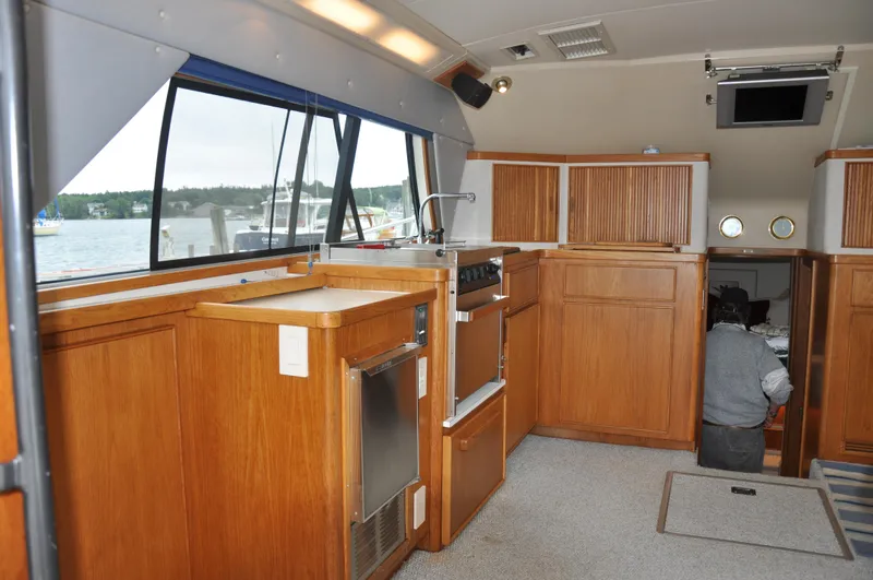 Slide: The Image of Interior of 1987 Bertram 37 Convertible yacht with wooden cabinetry and kitchen appliances. - 38