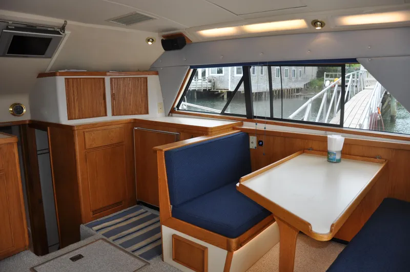 Slide: The Image of 1987 Bertram 37 Convertible interior with dining area and waterfront view. - 39