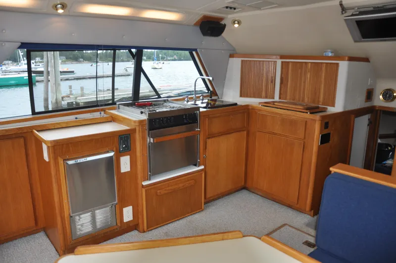 Slide: The Image of Interior of 1987 Bertram 37 Convertible yacht with wooden cabinetry and marina view. - 40