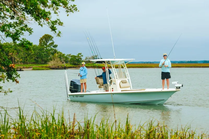 The Image of 2024 Key West 250 Bay Reef boat with anglers fishing in a serene lake. - 0