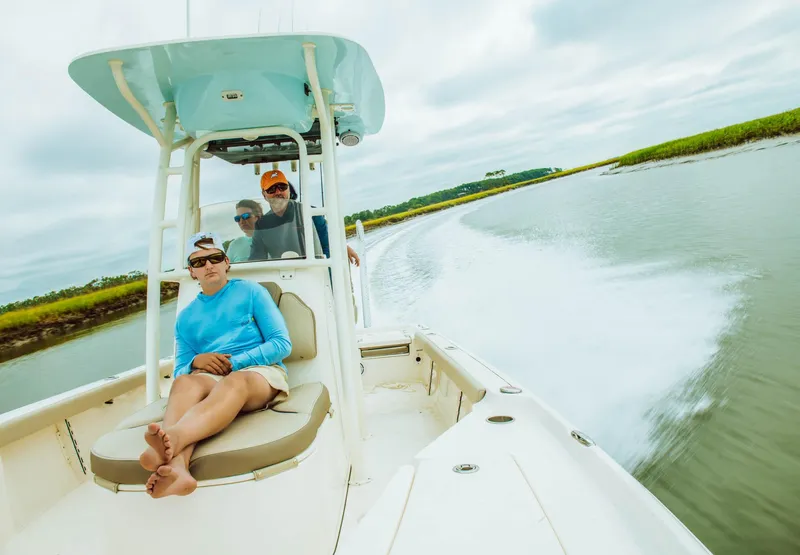 Slide: The Image of 2024 Key West 250 Bay Reef boat cruising with passengers on a scenic waterway. - 20