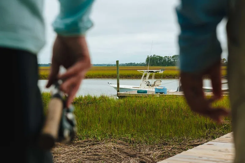 Slide: The Image of 2024 Key West 250 Bay Reef boat docked in a serene marshland. - 22