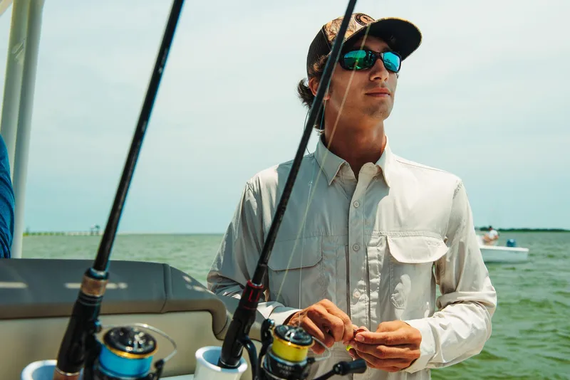 Slide: The Image of Man fishing on 2025 Key West 250 Bay Reef boat, holding fishing rods. - 34