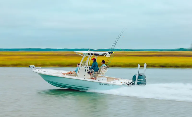 Slide: The Image of 2025 Key West 250 Bay Reef boat speeding on water, scenic marshland background. - 36