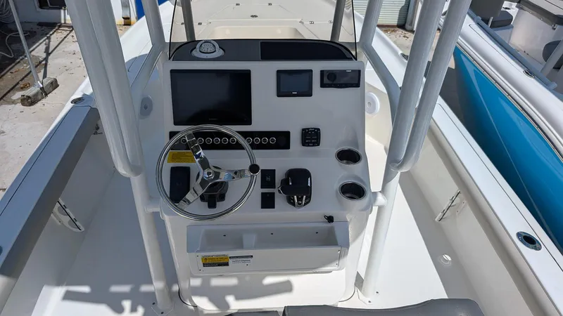 Slide: The Image of 2025 Key West 250 Bay Reef boat console with steering wheel and navigation controls. - 4