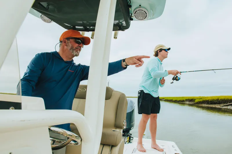 Slide: The Image of Two people fishing on a 2026 Key West 250 Bay Reef boat. - 43