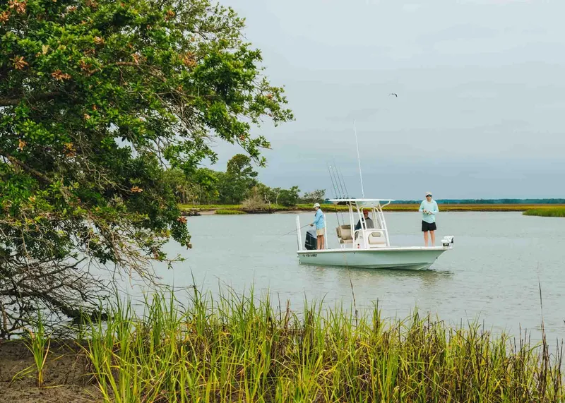 Slide: The Image of 2026 Key West 250 Bay Reef boat on calm water near lush greenery. - 48