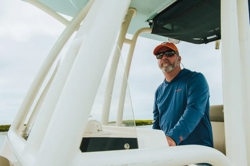 Slide: The Image of Man steering 2026 Key West 250 Bay Reef boat, wearing sunglasses and cap. - 49