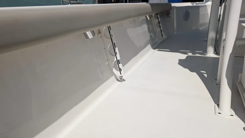 Slide: The Image of 2025 Key West 250 Bay Reef boat interior, showcasing sleek white deck and side railings. - 6