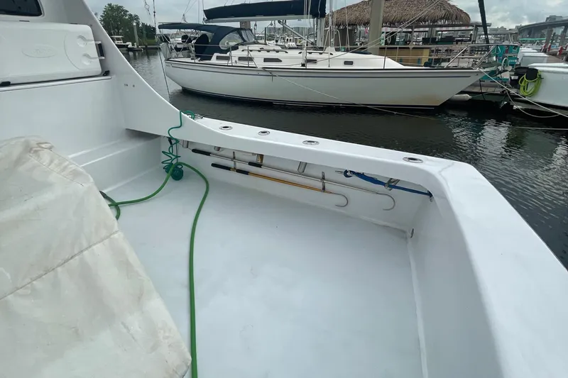 Slide: The Image of 2004 Custom Carolina 47 Alex Willis boat deck with docked sailboats in the background. - 12