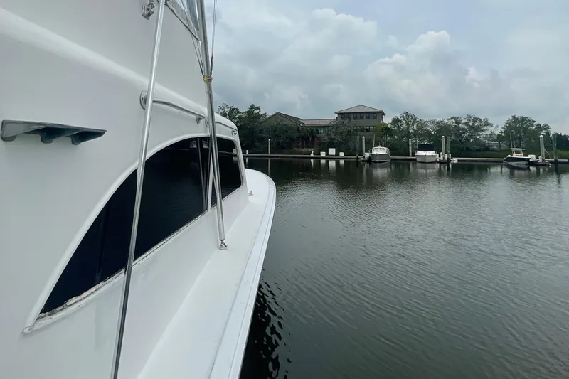 Slide: The Image of Side view of 2004 Custom Carolina 47 Alex Willis yacht docked in a marina. - 23