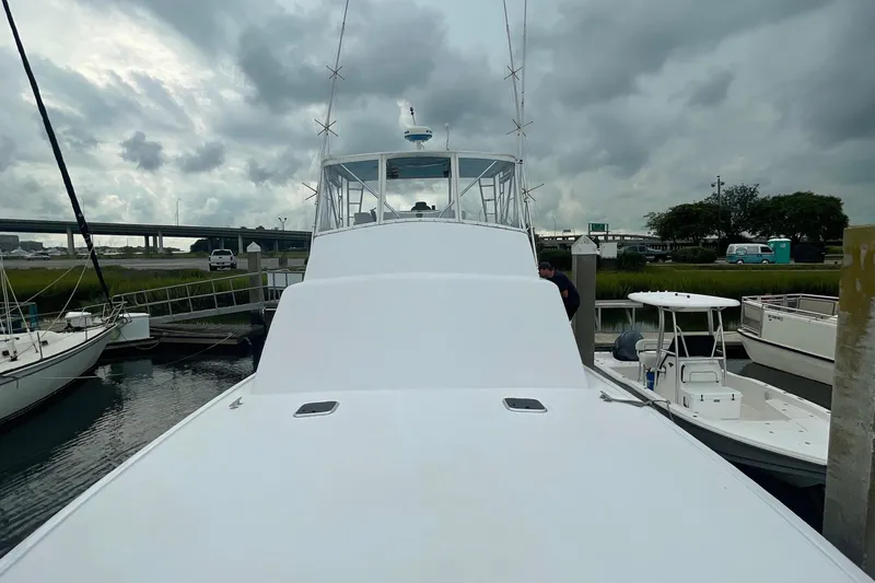 Slide: The Image of 2004 Custom Carolina 47 Alex Willis boat docked at a marina under cloudy skies. - 24