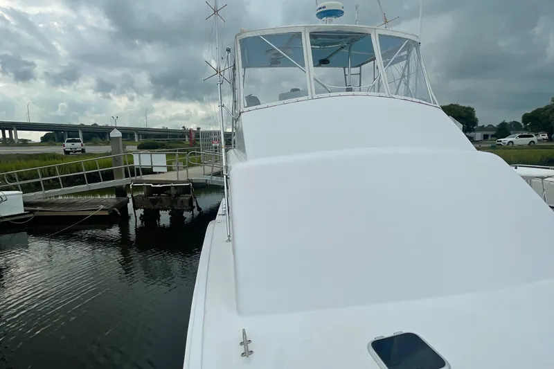 Slide: The Image of 2004 Custom Carolina 47 Alex Willis boat docked at a marina under cloudy skies. - 26