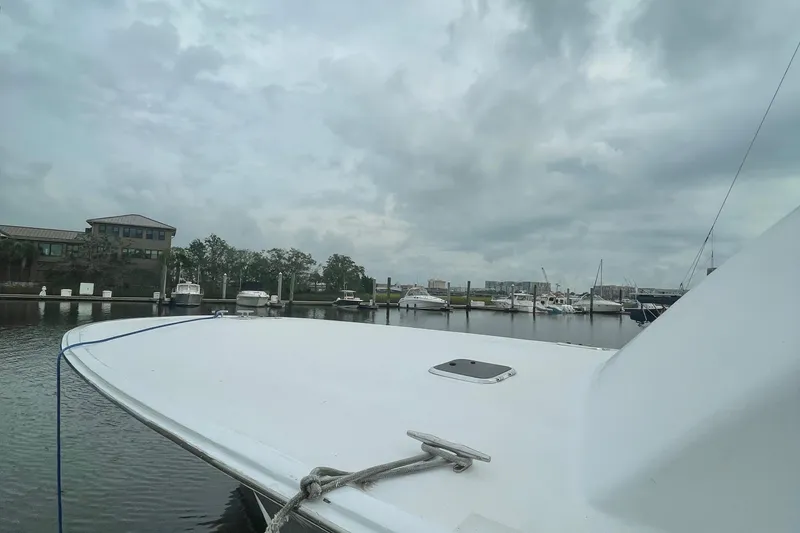 Slide: The Image of Custom Carolina 47 Alex Willis 2004 boat docked in a marina on a cloudy day. - 4