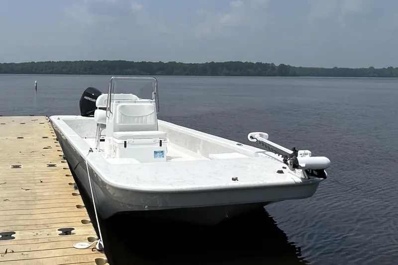 Slide: The Image of 2024 Coastal Skiff 271 boat docked on a calm lake. - 22